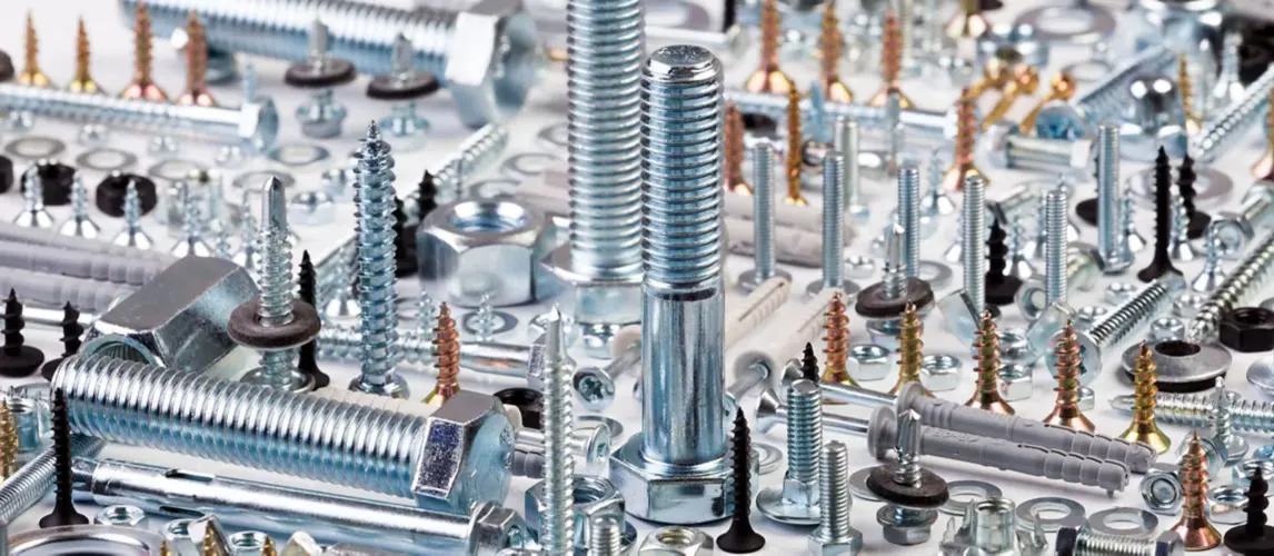 Zinc-plated bolts, screws, nuts, fixings and anchors laid out on the counter