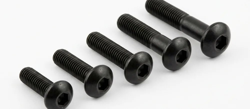Black button head socket screws in a stepped row, threads pointing to the top left