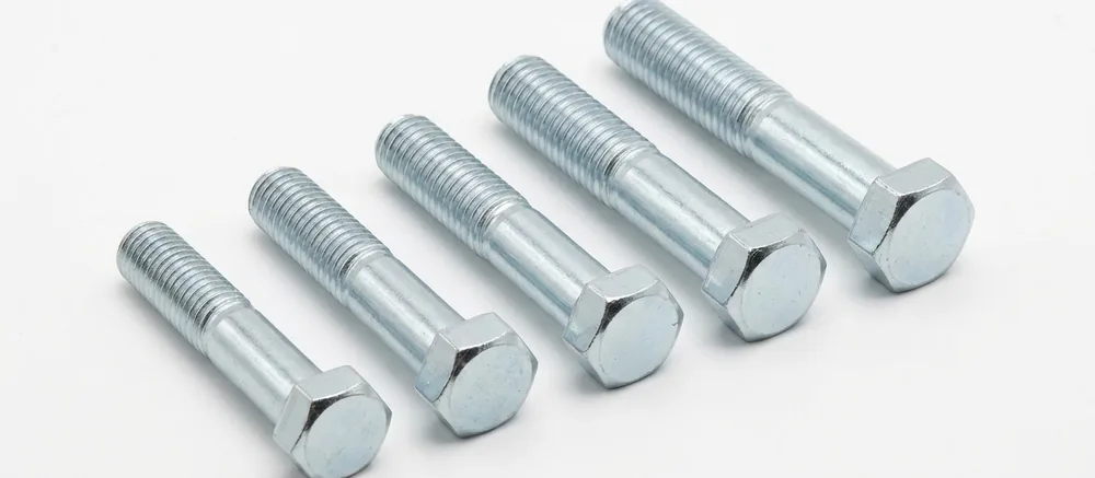 Bright zinc hex bolts in a stepped row, threads pointing to the top left