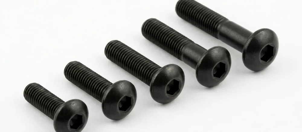 Self-colour button head socket screws in a row, threads pointing to the top left