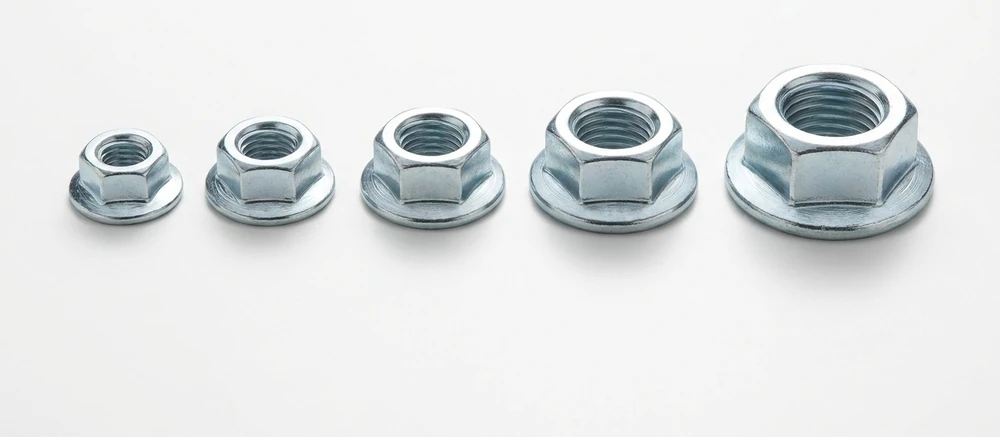Five zinc plated flange nuts in a row on white, each with a serrated circular flange at its base