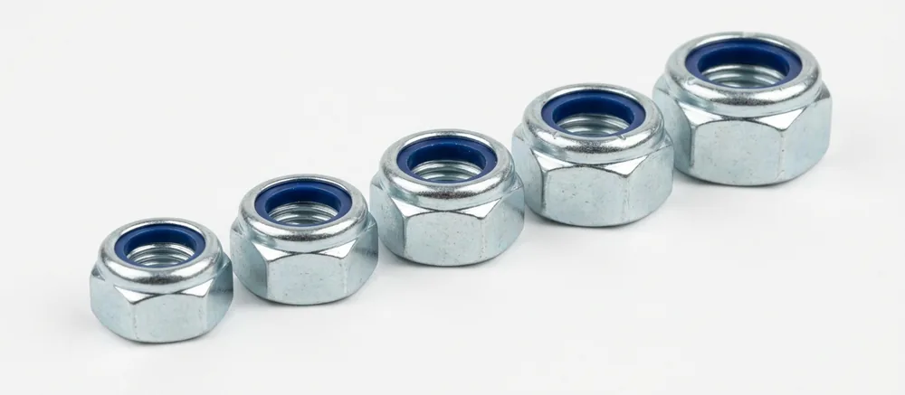 Five zinc plated nyloc nuts in a row on white, each with its blue nylon insert visible inside the top collar